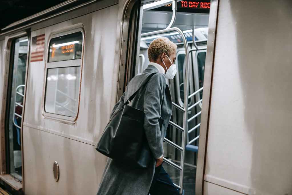 black woman in mask entering metro train